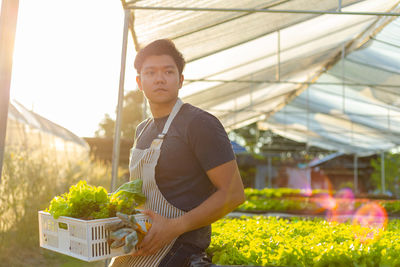 Young man holding ice cream in greenhouse