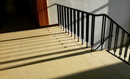 Shadow of railing on tiled floor in school