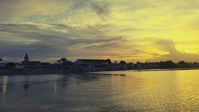 sunset, water, waterfront, sky, building exterior, architecture, cloud - sky, built structure, reflection, scenics, orange color, cloudy, beauty in nature, cloud, tranquility, tranquil scene, river, nature, sea, lake