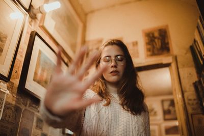 Woman gesturing stop sign at home