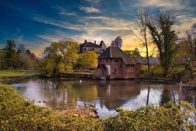 Buildings by lake against sky