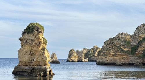 Rock formations in sea against sky
