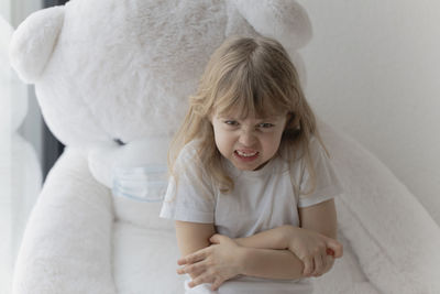 Portrait of girl making face while sitting at home