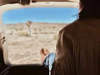 Rear view of woman looking through window