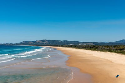 Scenic view of beach against clear blue sky