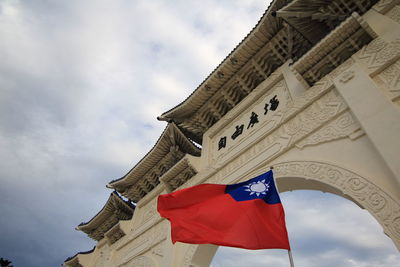 Low angle view of flag on building against sky