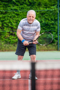 Full length portrait of man playing tennis