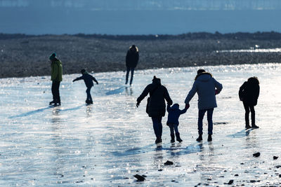 People walking on snow covered landscape