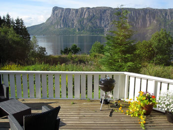 People on table by lake against mountains