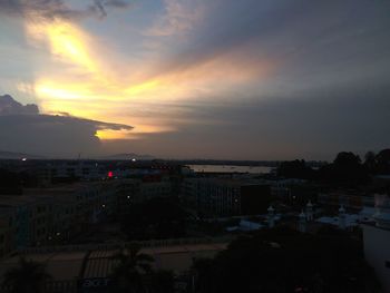 High angle view of silhouette buildings against sky at sunset