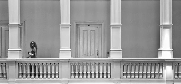 Woman standing by railing of building