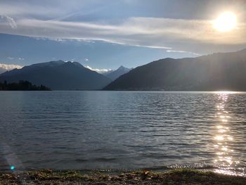 Scenic view of lake by mountains against sky