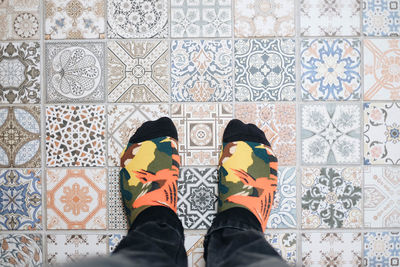 Low section of man standing on tiled floor