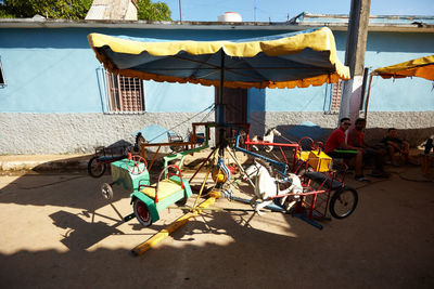 Bicycles on beach in city against sky