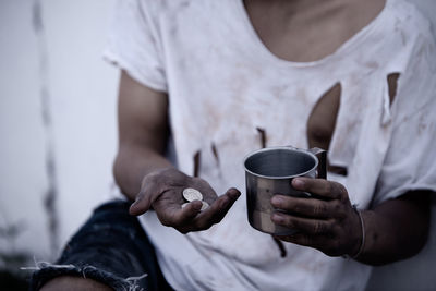 Midsection of man holding coffee cup