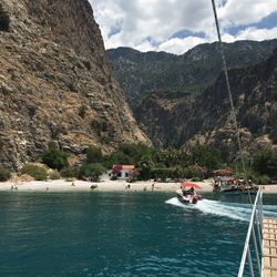 Sailboats on sea against mountains