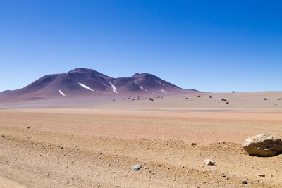 Scenic view of desert against clear blue sky