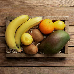 Orange, banana, mango, kiwi and lemon top view flat lay with copy space for some advertisement text