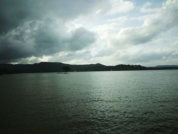 Scenic view of sea against storm clouds