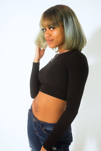 Portrait of woman with dyed hair standing against white background