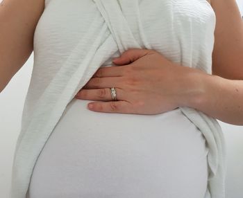 Midsection of pregnant woman wearing ring