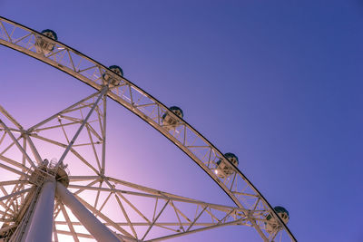 Low angle view of ferris wheel against clear blue sky