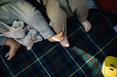 Low section of babies lying on bed