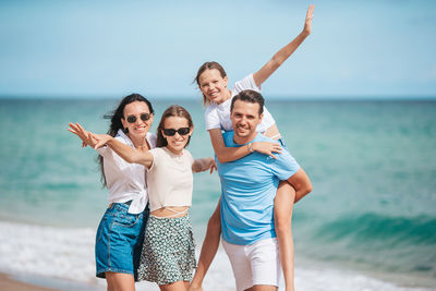 Happy friends standing at beach