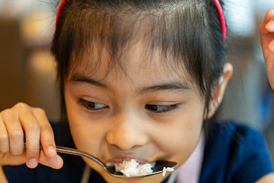Close-up of cute girl eating food at restaurant