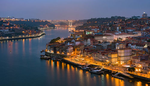 High angle view of illuminated city by river at night