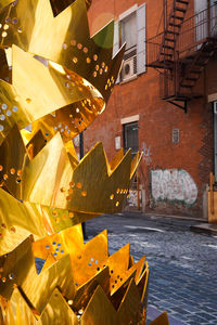 Yellow decorations hanging by building in city