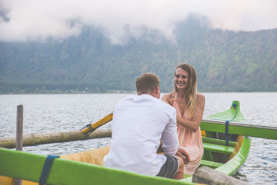 Friends sitting on boat in lake