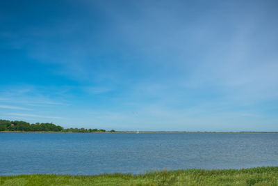 Scenic view of sea against blue sky