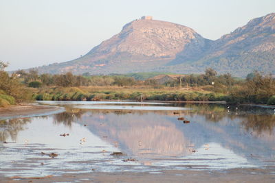 Scenic view of lake by mountain against sky