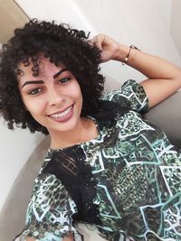 Portrait of happy woman with braces sitting on chair