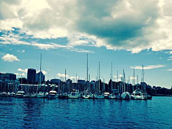 Boats in harbor with city in background