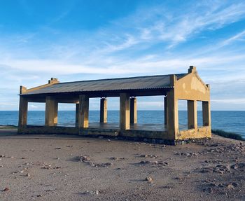 Built structure on beach against sky