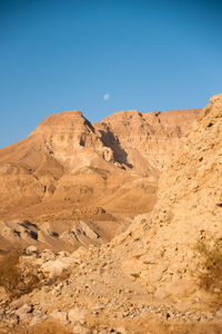 Scenic view of desert against clear blue sky