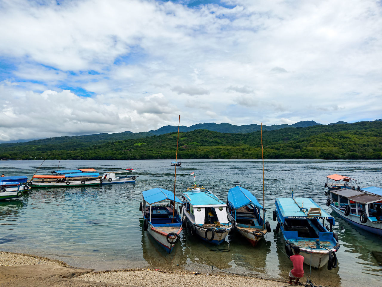 BOATS MOORED ON SHORE AGAINST SKY