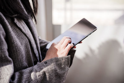 Midsection of woman using mobile phone