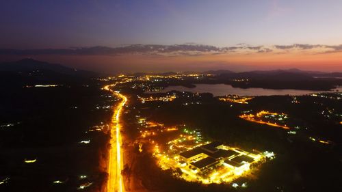 High angle view of illuminated cityscape against sky at night