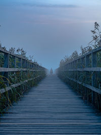 Footbridge over footpath against sky