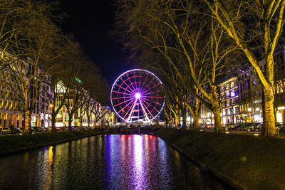 Illuminated ferris wheel at night