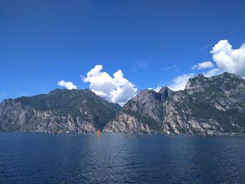 Scenic view of sea and mountains against blue sky