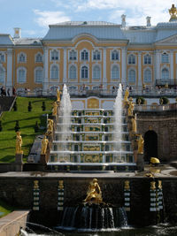 Fountain and buildings against sky in city