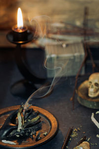 Smoke emitting from of twig by human skull during halloween