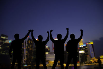 Rear view of silhouette people standing at night