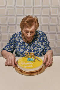 Portrait of old lady sitting on sofa at home