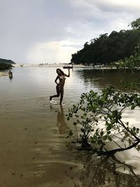 Man in lake against sky