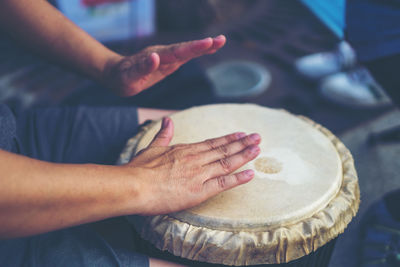 Cropped hands of man playing drum